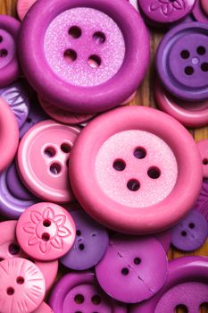 A lot of pink and purple sewing buttons closeup