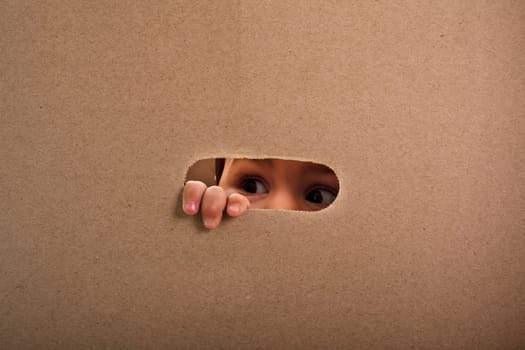 A small child looking out the gap of craft box