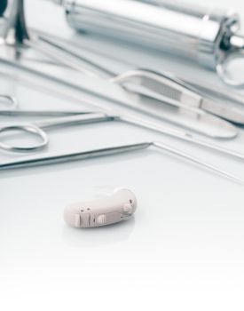 Medical instruments for ENT doctor on white and hearing aid, alternative to surgery