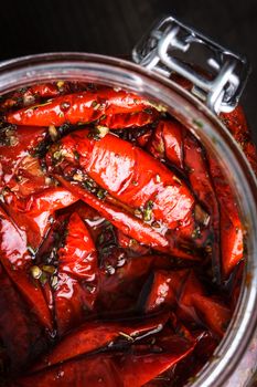 Sun dried tomatoes with herbs and olive oil in jar