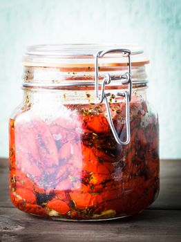 Sun dried tomatoes with herbs and olive oil in jar