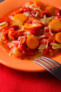 Stewed vegetables on the orange plate and red napkin