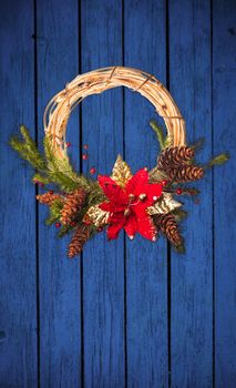 Christmas wreath with poinsettia on the old blue wooden doors