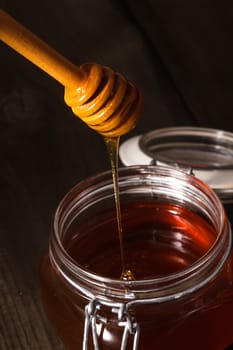 Honey drip in jar on the table