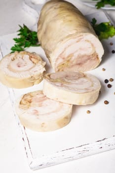 A baked chicken roll on the white cutting board