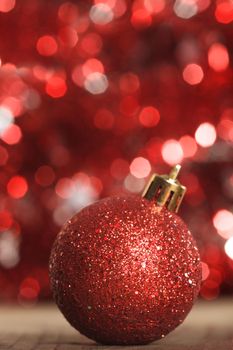 A red christmas bauble on the background of red boken