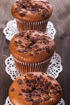 Chocolate muffins with chocolate chips on the wood background closeup