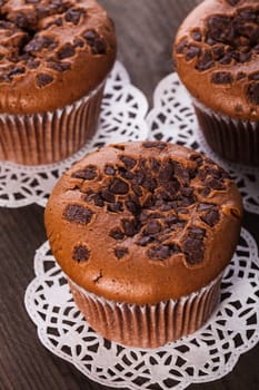 Chocolate muffins with chocolate chips on the wood background closeup