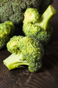 Green broccoli on the wood background closeup