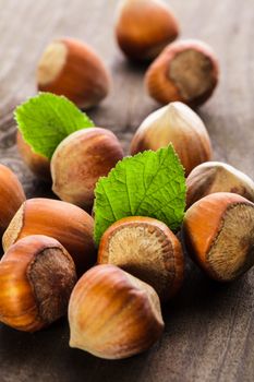 Hazelnuts with shell and green leaf on the wooden table