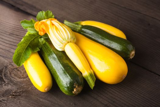 Yellow and green zucchini on the wood background