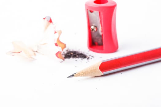 A pencil with red sharpener on white background isolated