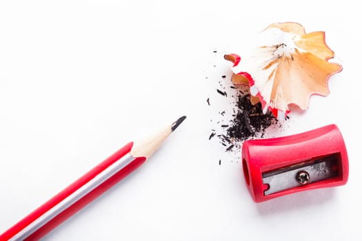 Red sharpener and pencil isolated on white paper