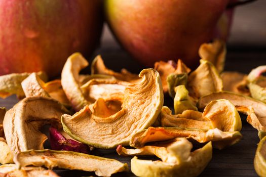 Slices of dried apples on fruit background closeup