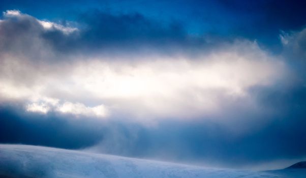 Snowstorm with sunshine high up in the mountains