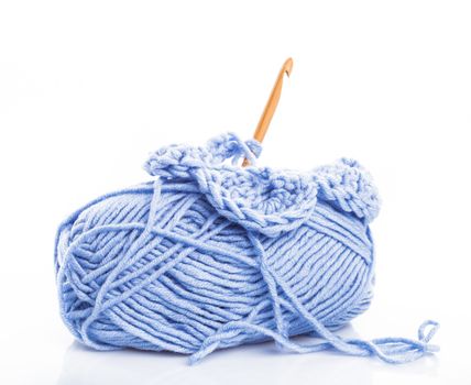 Crocheting with blue threads isolated on white