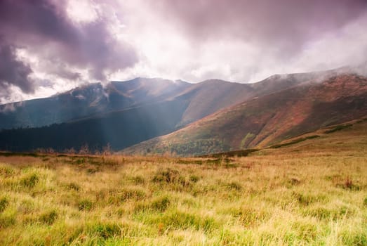 Autumnal hills high up in Carpathian mountains and sunrays