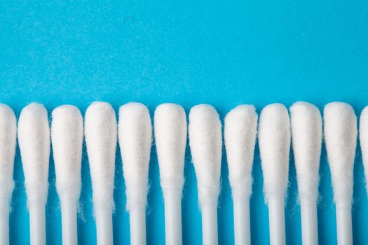 White cotton ear sticks on blue background macro