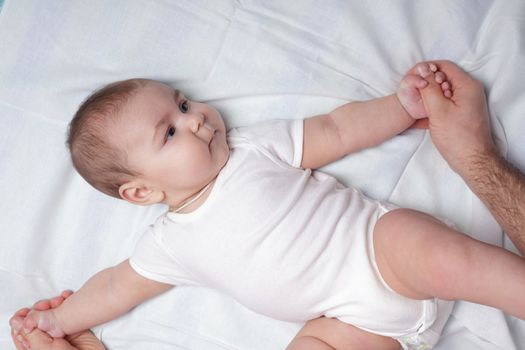 Father do everyday exercises and massaging with baby