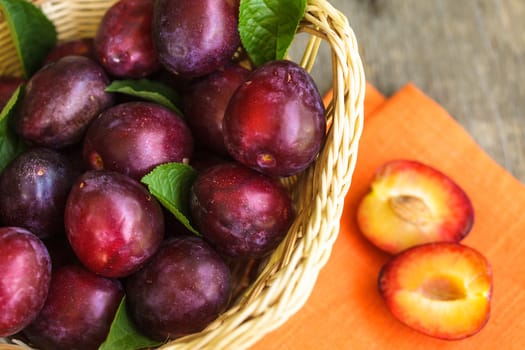 Half of a purple plum on the wooden table