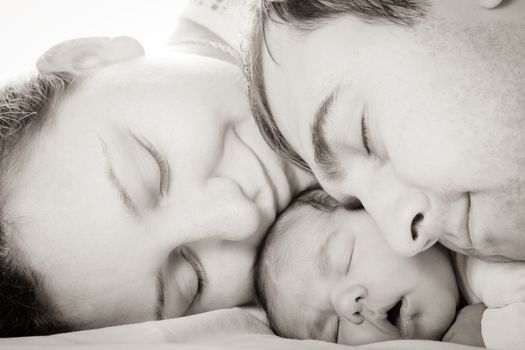 Sleeping baby with mom and dad, closeup faces