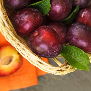 Purple plums on the rustic wooden table