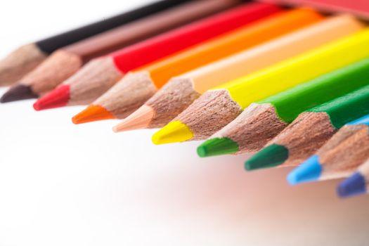 Rainbow color pencils in a row isolated on white