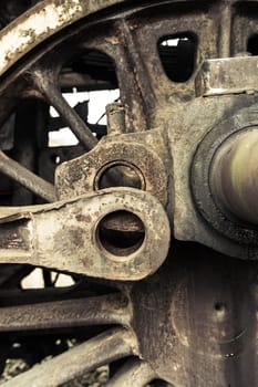 A fragment of an old damaged and rusty steam engine, old style type locomotive, vertical frame.