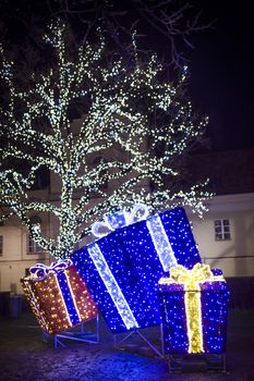 Night christmas decorations, illuminated christmas presents and illuminated tree.