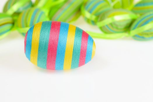 Photo presents Easter decorated striped eggs scatterded on white background.