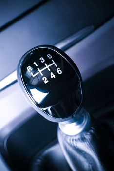 Interior of car, vehicle with visible lever of manual  transmission, with metal, chrome elements.