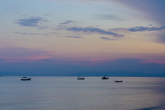 Small fishing boats anchor near bay in the evening