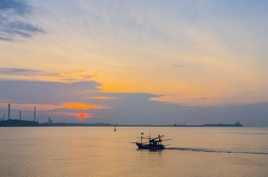 Large oil tanker and small fishing boat  in the morning