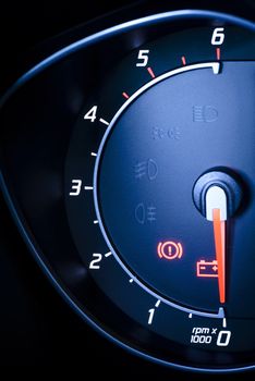 Photo presents car's, vehicle's speedometer or tachometer with visible information display - ignition warning lamp  and brake system warning lamp, visible symbols of instrument cluster ( ten check warning light), with warning lamps illuminated.