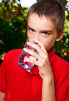 Cute boy drinking water outdoors