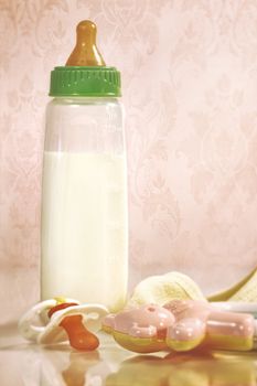 Baby bottle with milk and pacifier on counter