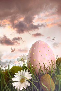 Large pink egg with daisies in tall grass 