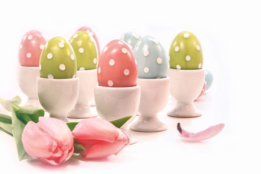 Colorful spotted easter eggs in white cups