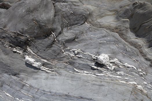 Grey coastal rock formation with marbling, Lantic Bay, Cornwall, England.