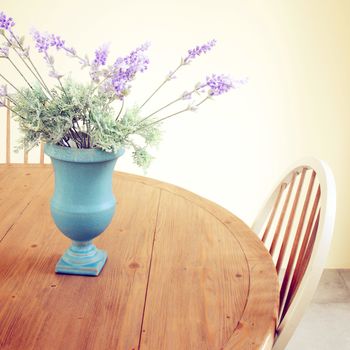 Flowers in vase on the table with retro filter effect