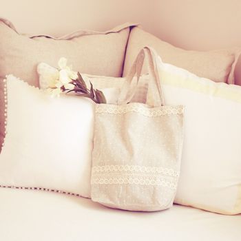 Cute tote bag and pillows on bed with retro filter effect