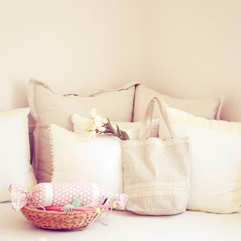 Knitting needles in basket and cute tote bag on the bed with retro filter 