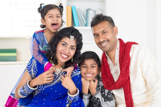 Happy smiling Indian family at home. Living lifestyle of parents and children in their traditional dress in modern house.