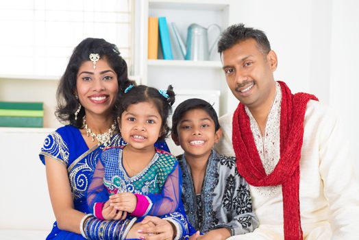 Happy Indian family at home. Living lifestyle of parents and children in their traditional dress in modern house.