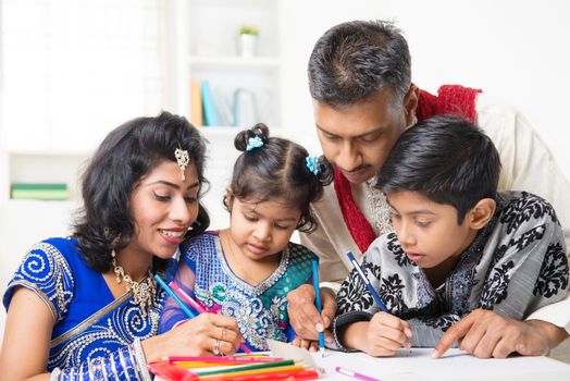 Asian Indian family drawing and painting picture at home. India family lifestyle. Happy parents and children having fun.