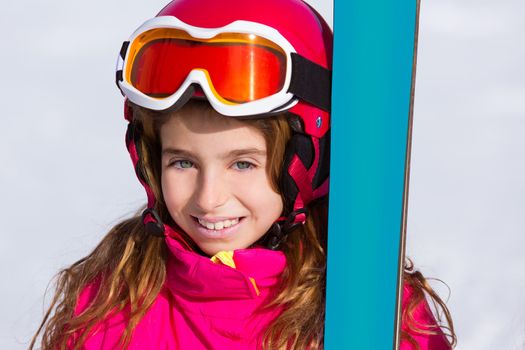 Kid girl winter snow portrait with ski equipment helmet and goggles