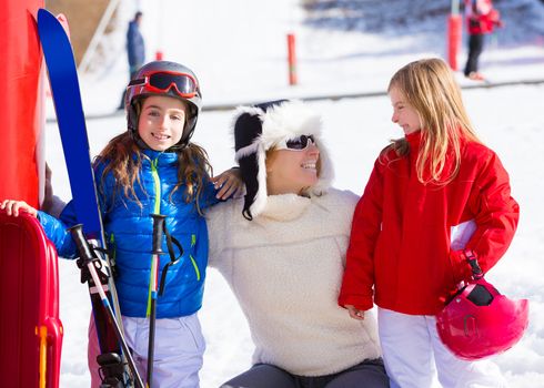 snow winter family in ski track mother and daughters smiling happy with equipment