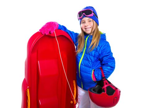 Blond kid girl with red sled and snow equipment helmet and goggles on white background
