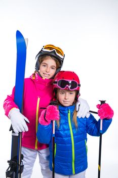 siters kid girls with ski poles helmet and goggles going to winter snow