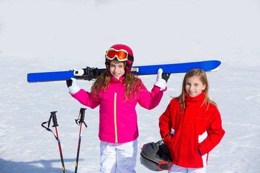 Kid girls sister in winter snow with ski equipment helmet goggles poles